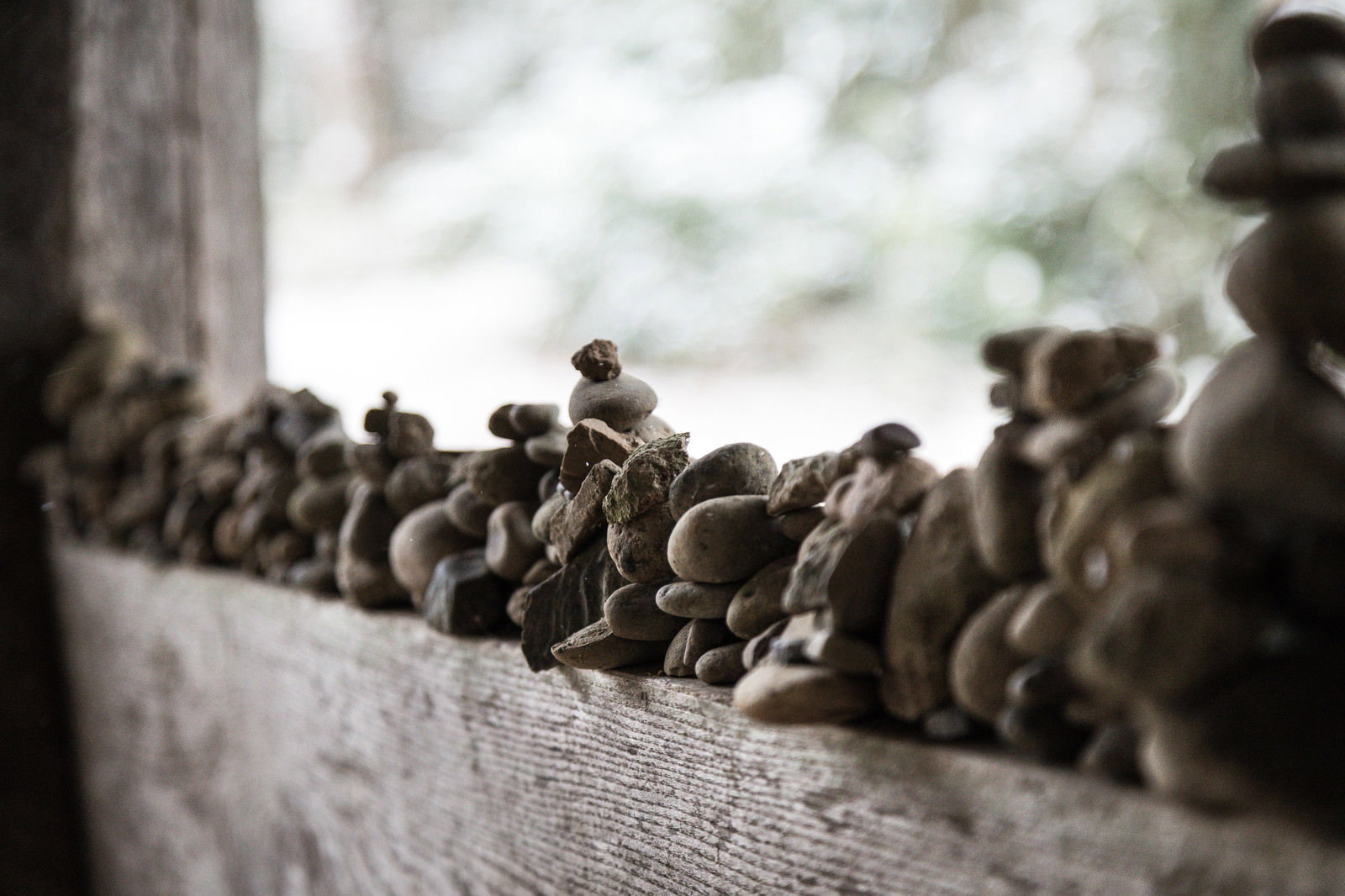 中尊寺の石垣に積み重ねられた小さな石と奥にぼける寺院建物