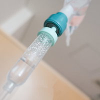 点滴ポタポタ、透明なチューブから滴下する薬液の写真