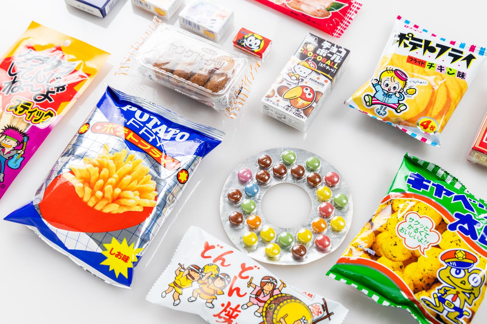 白背景に並んだ懐かしいスナック菓子や駄菓子の詰め合わせ