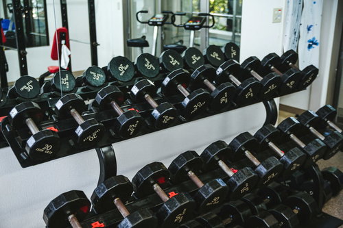 重さの異なるトレーニングジムのダンベルが並んだラック