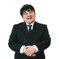 黒いスーツの会社員が愛想笑いをする営業マンの笑顔の写真