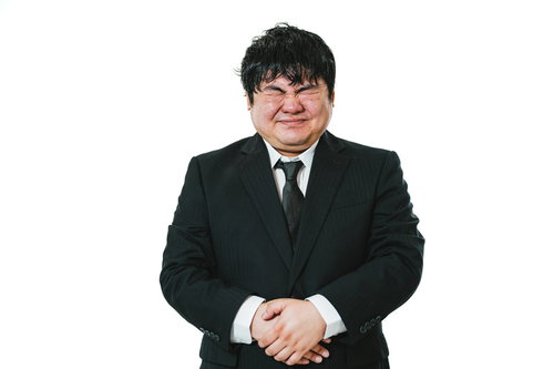 （めっちゃ、おなかいたい）お腹を押さえて苦しむスーツ姿の男性会社員