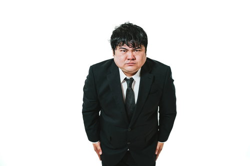 真摯に受け止めておりますと深くお辞儀するスーツ姿の男性