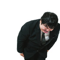 まったく悪びれた様子がない謝罪をする黒いスーツの男性の写真