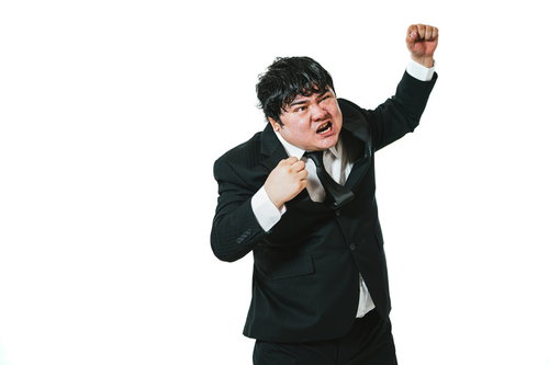 黒いスーツの会社員がする弱気の勝値ガッツポーズ