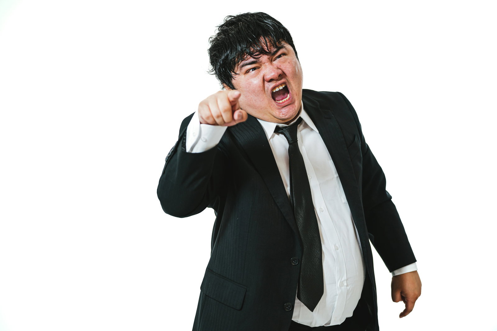 指を差して怒鳴りつけるスーツ姿の男性会社員［モデル：段田隼人］