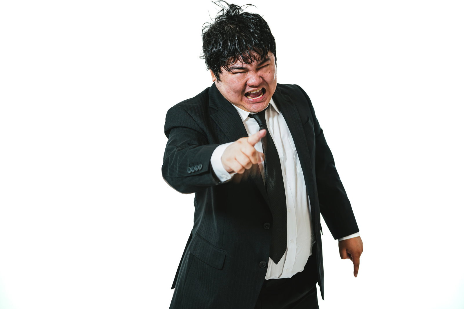 怒りながら左手を突き出して怒鳴るスーツ姿の男性会社員［モデル：段田隼人］
