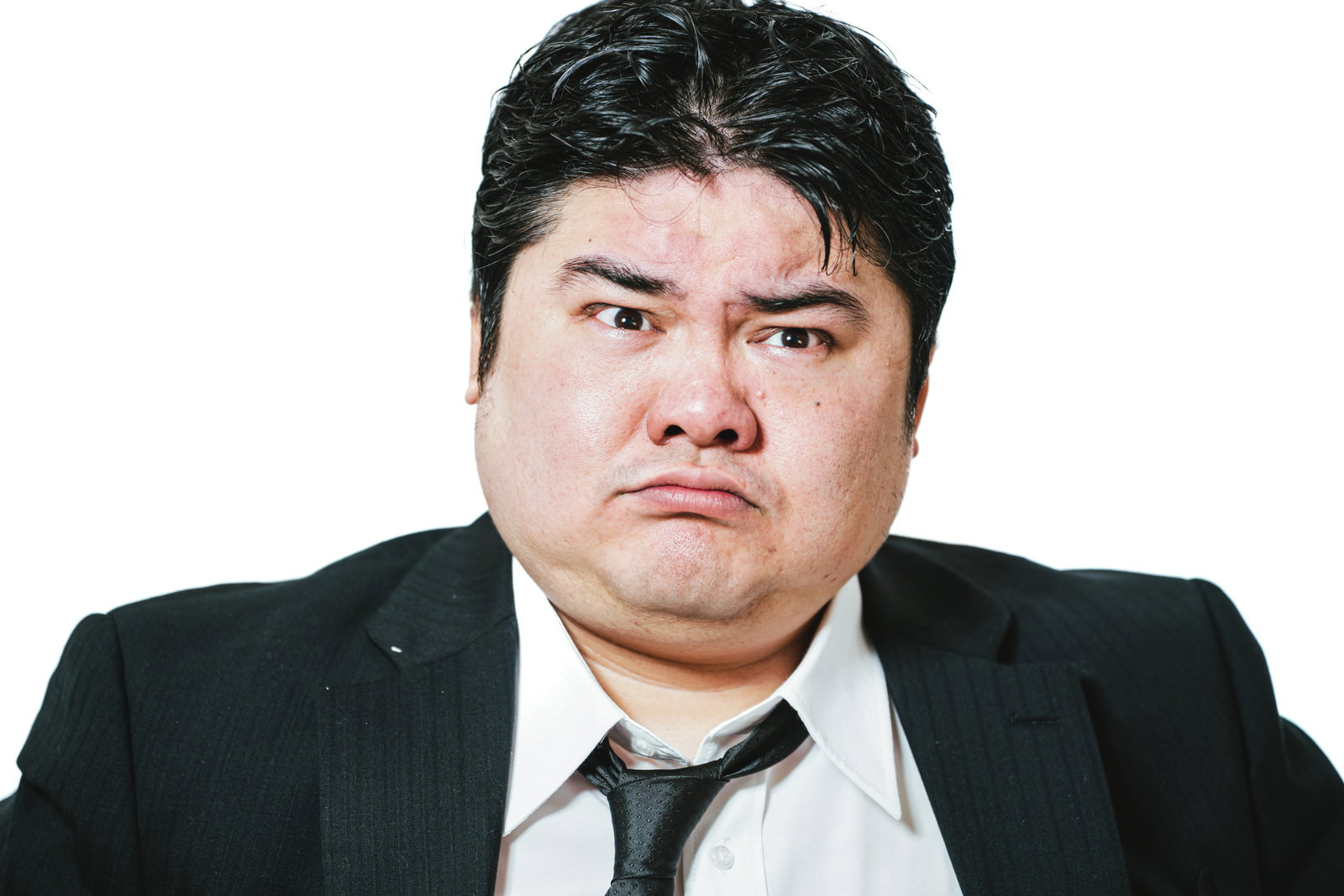 スーツを着た男性が怒りの表情を浮かべている［モデル：段田隼人］