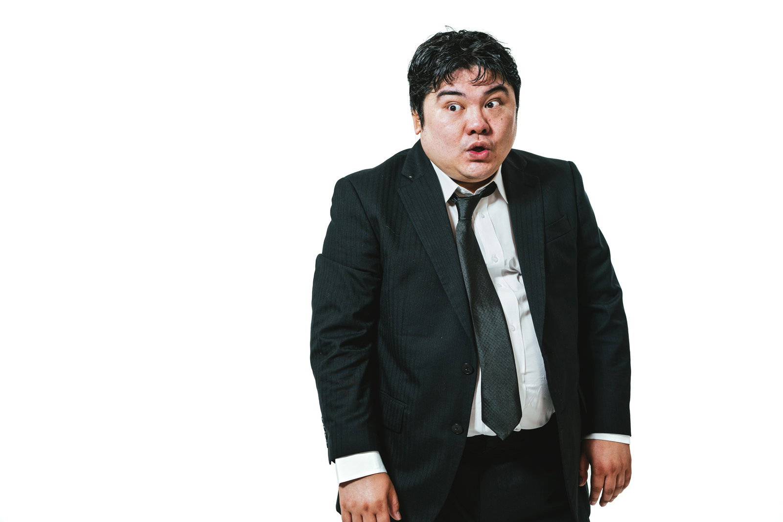 黒いスーツを着た男性がこっそりと驚いた表情で身を潜めている［モデル：段田隼人］