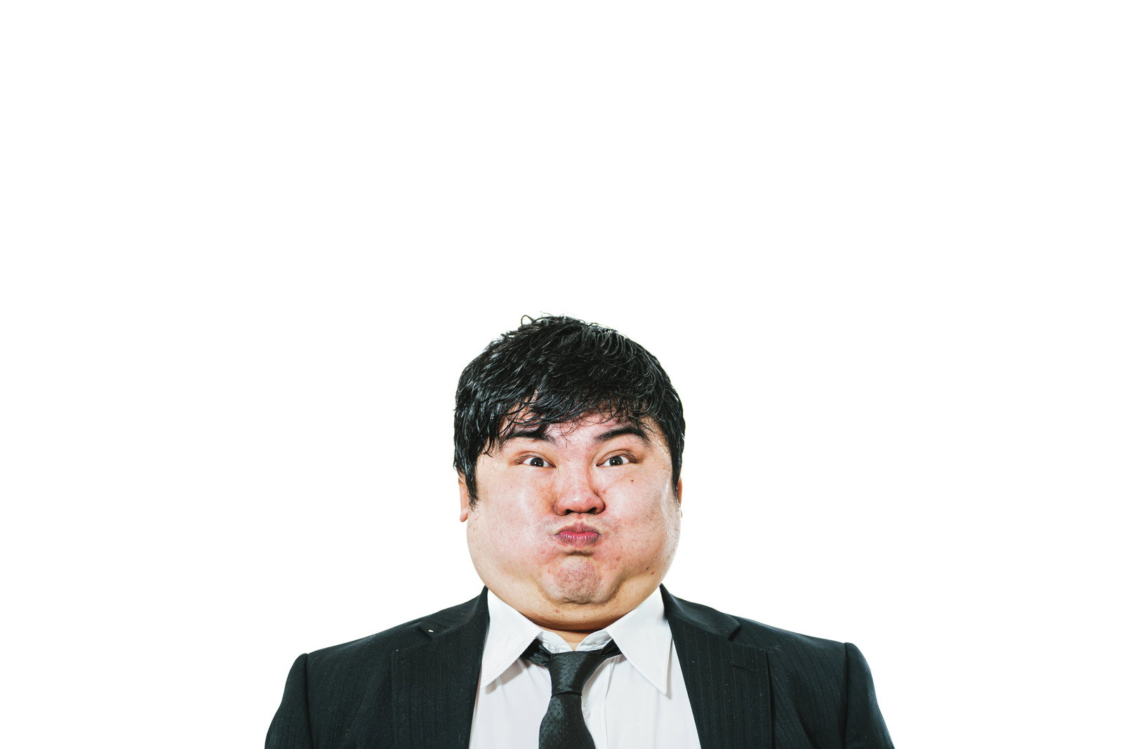 スーツ姿で口をつぐんで息を止めている男性［モデル：段田隼人］
