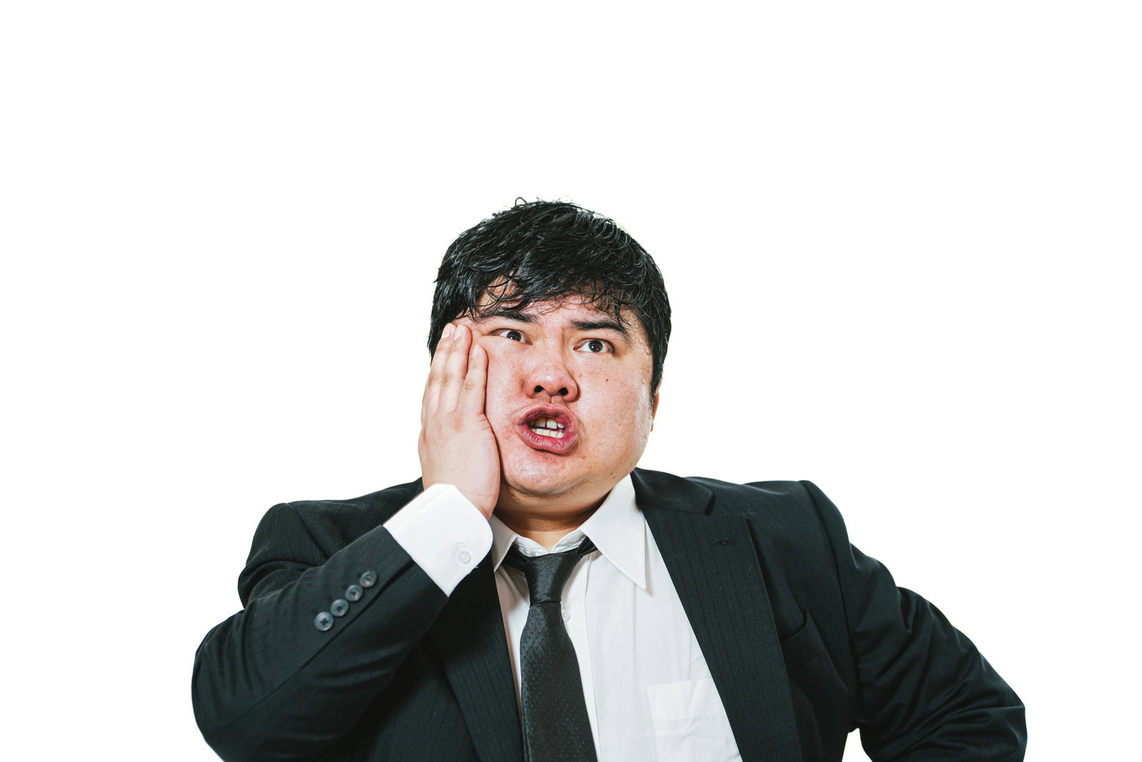 歯の痛みで右頬に手を当てて困った表情をするスーツ姿の男性［モデル：段田隼人］