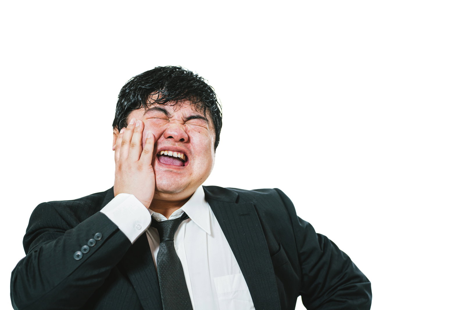 苦い顔で頭を抱えるスーツ姿の男性会社員［モデル：段田隼人］