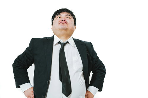 スーツ姿で威張り散らすエンジニア男性の高圧的なポーズ