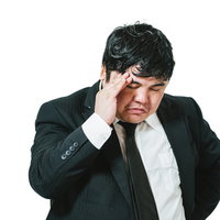 スーツ姿で頭を抱えて考え込む男性社員の悩む表情の写真