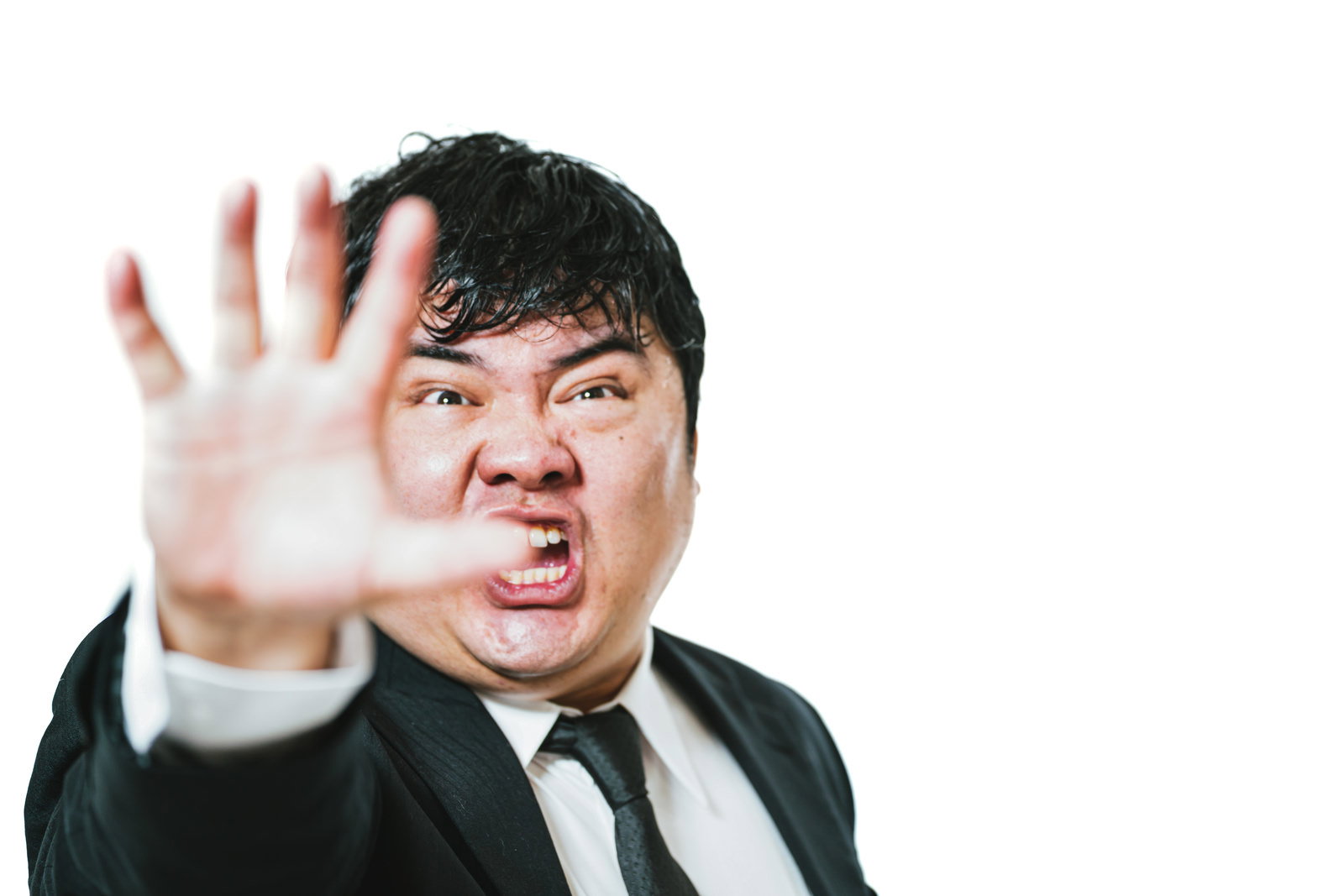 手のひらを前に出して制止のポーズをとるスーツ姿の男性［モデル：段田隼人］