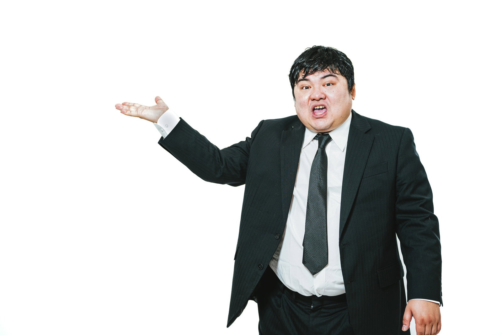 黒いスーツを着た営業マンが片手を広げて新製品を説明している［モデル：段田隼人］