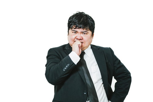 イライラしてストレスで爪を噛む会社員の男性