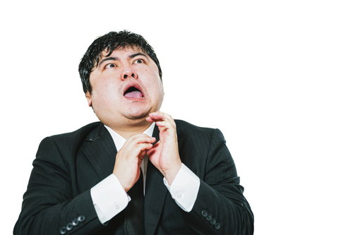 ネクタイを緩める驚愕表情の男性