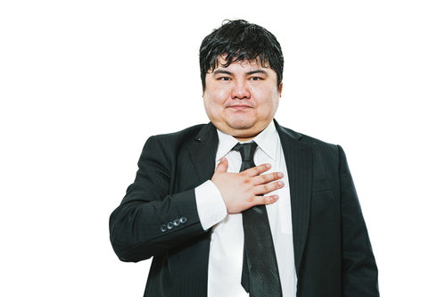 胸に手を置いて誓いの姿勢を示す男性会社員