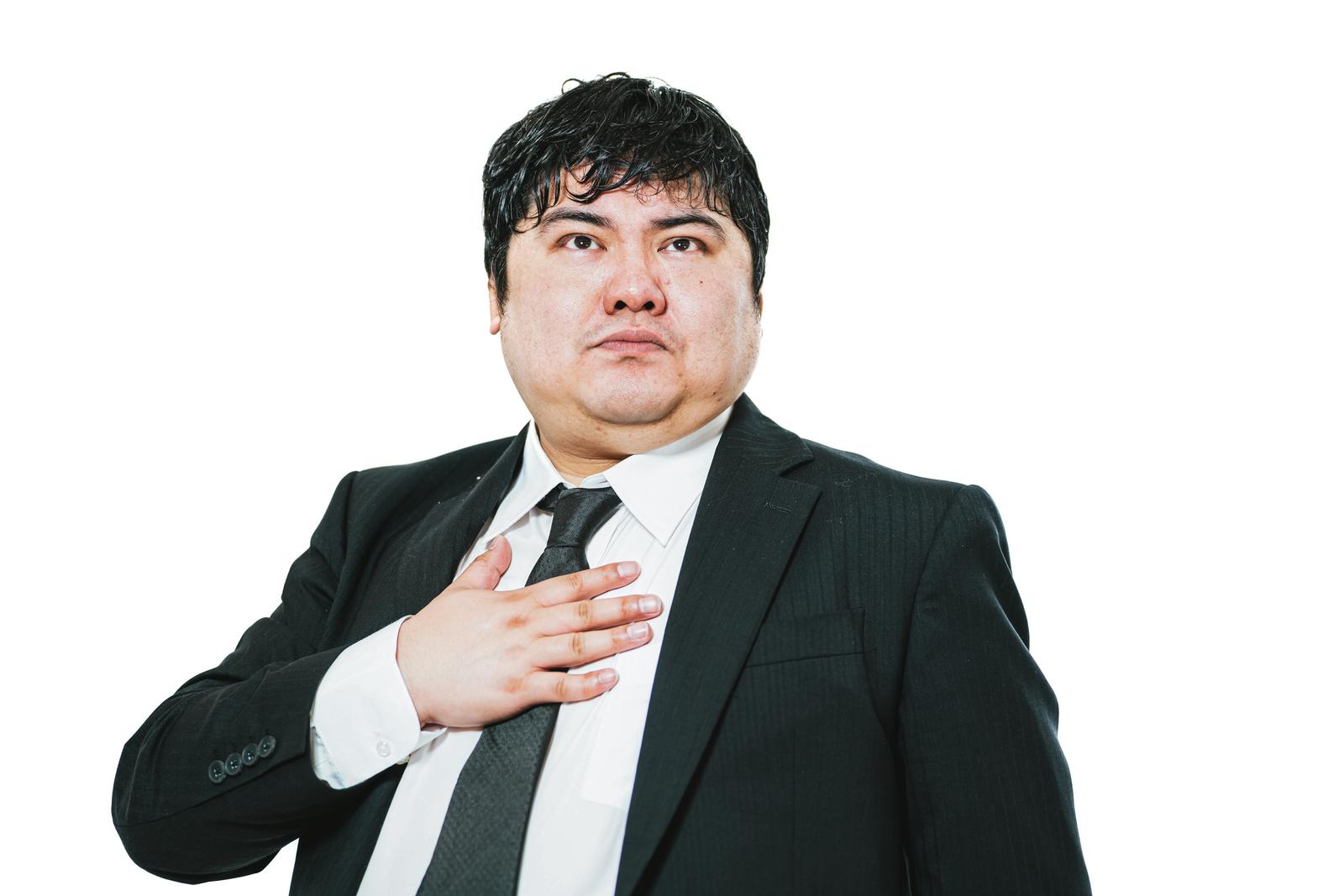 Upper body of a suited man taking an oath with his right hand on his chest against a white background