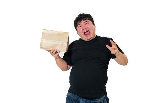 宅配物を手に持ちうろたえる男性の驚きの表情