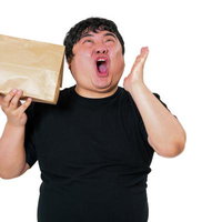 物が届いて段ボール箱を持ち大喜びする男子の写真