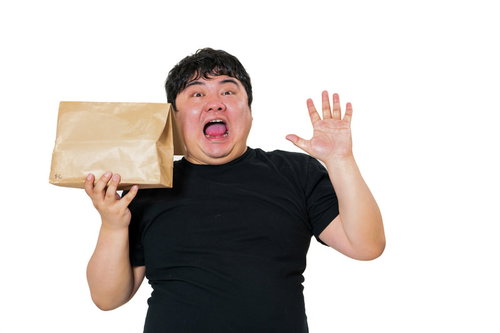 紙袋を片手に慌てふためく黒いTシャツの男性