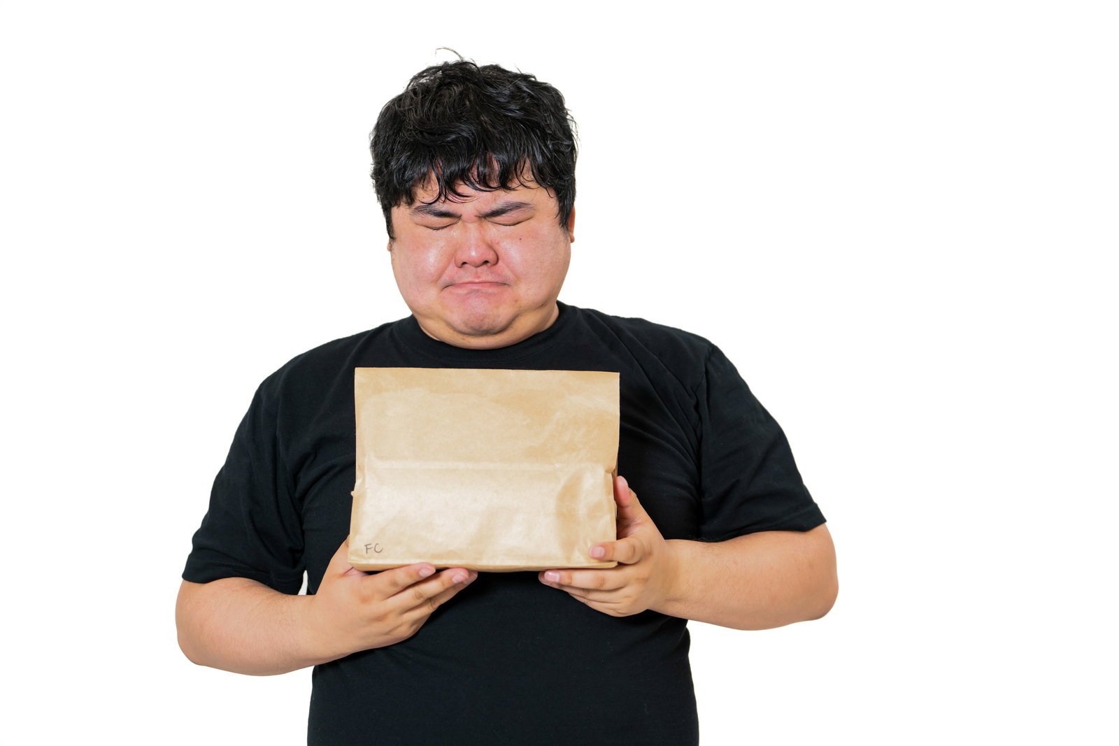 茶色の封筒を両手で持ち困った表情で考え込む眼鏡をかけた男性［モデル：段田隼人］