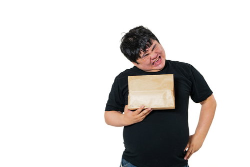 荷物を片手にがっかりする男性の配達受け取り