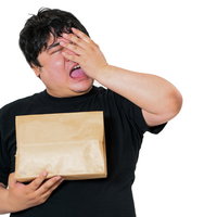 届いた商品が思ったものと違った時の頭を抱える男性の写真