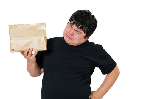 宅配物を片手に首をかしげる男性の戸惑う表情