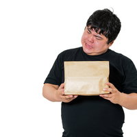 荷物の中身を想像して首をかしげる男性の受け取りの写真