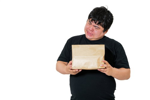 荷物の中身を想像して首をかしげる男性の受け取り