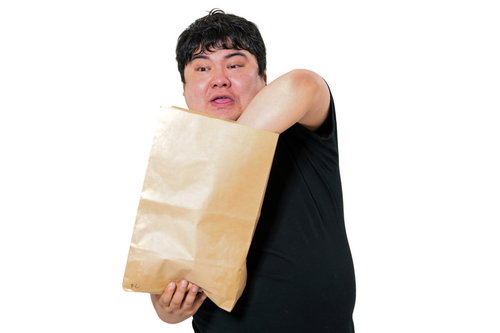 紙袋の中身を両手で探る男性、配送・宅配物の受け取り確認シーン