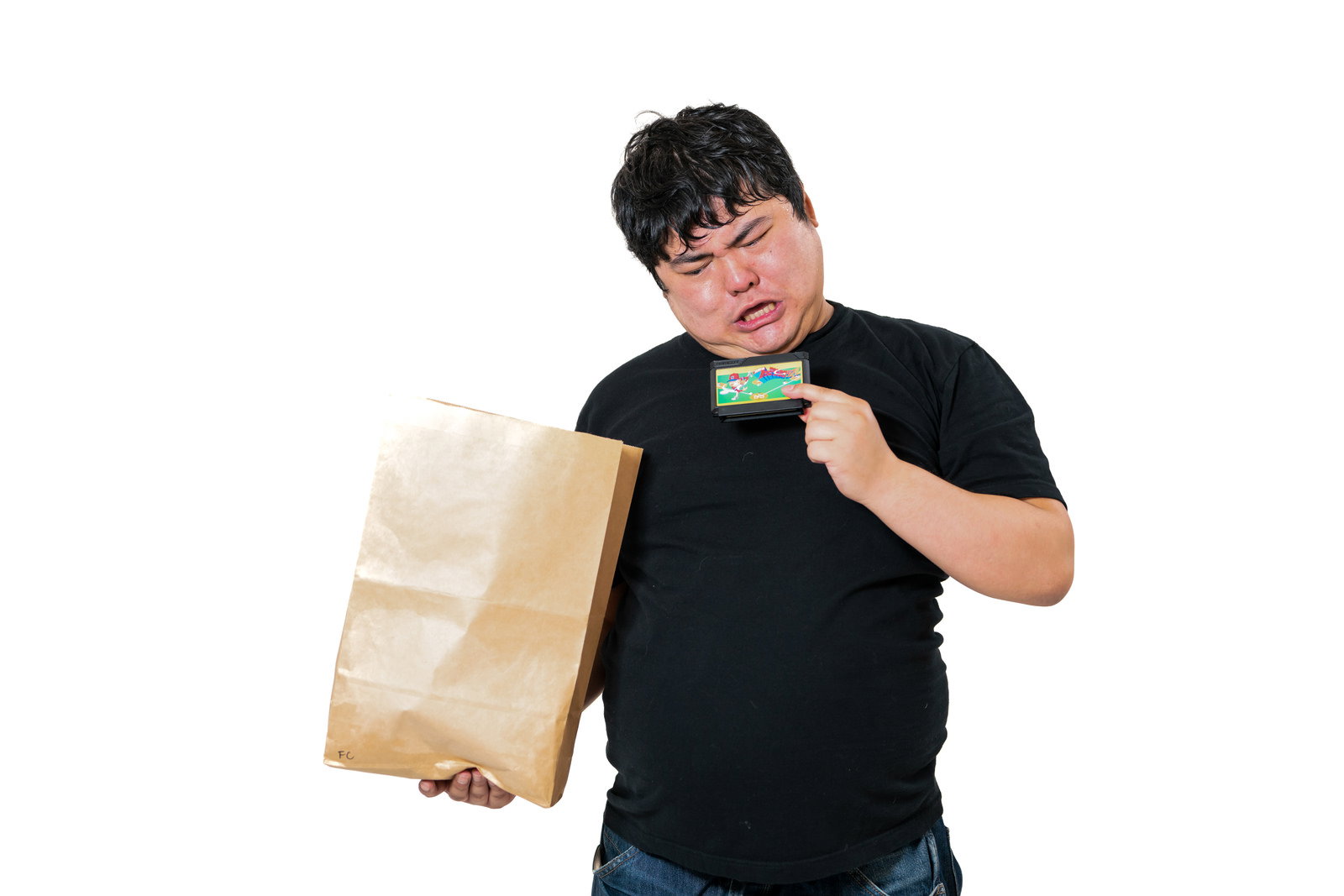 紙袋からカセットを取り出してがっかり表情を見せる男性［モデル：段田隼人］