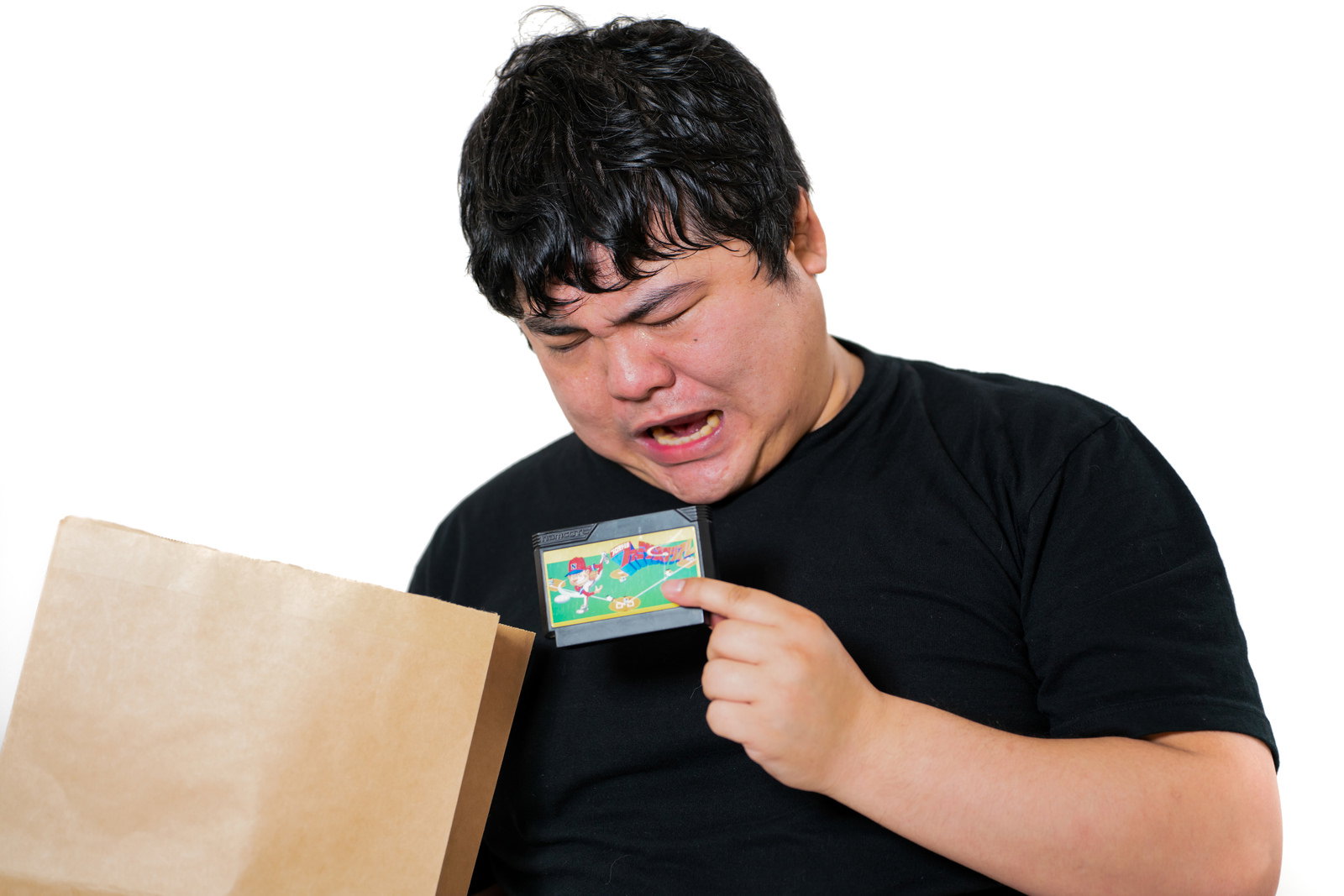 A man looking disappointed while opening a retro game cartridge