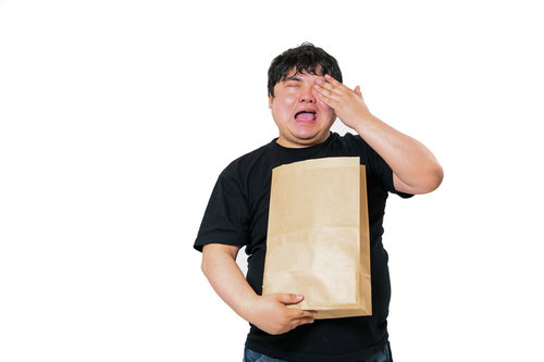 左目を押えて号泣する紙袋を持った黒いTシャツの男性