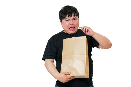 紙袋の荷物を持って焦る男性の受け取りと驚きの表情