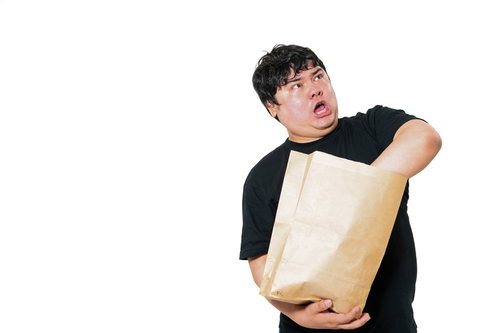 紙袋に入った小包の中身を手探りで確認する男性