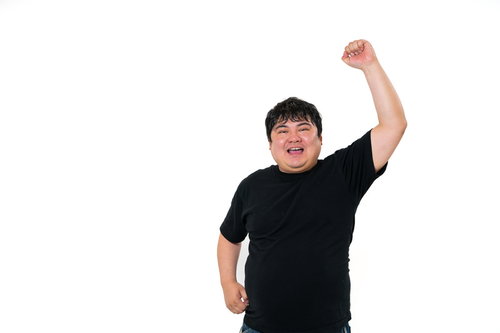 黒いTシャツで腕を突き上げて歓喜する男性