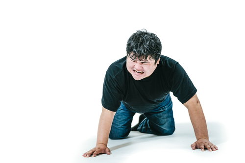 しかめっ面して土下座する男性