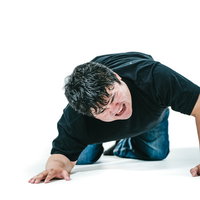 両手を地面について後悔の表情を浮かべる男性の写真