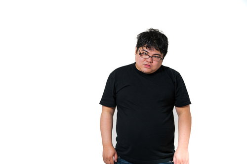 黒いTシャツを着た眼鏡の男性が放心状態で立ち尽くす