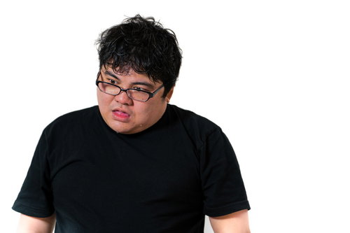 黒縁メガネをかけて愕然とした表情を浮かべる黒Tシャツの男性