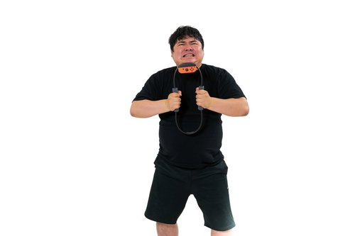 トレーニング器具を握り力を込めて運動する男性