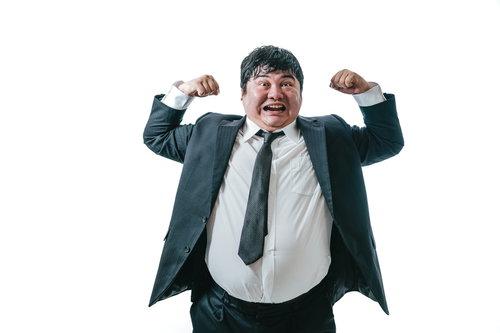 マッスルポーズで威張る会社員の勝気な表情