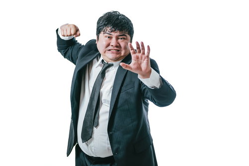 殴り返そうとする怒った会社員の男性、スーツ姿で激怒する職場トラブル