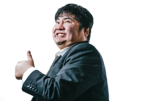 全力で親指を立てる男性会社員のポーズ、スーツ姿でグッジョブ