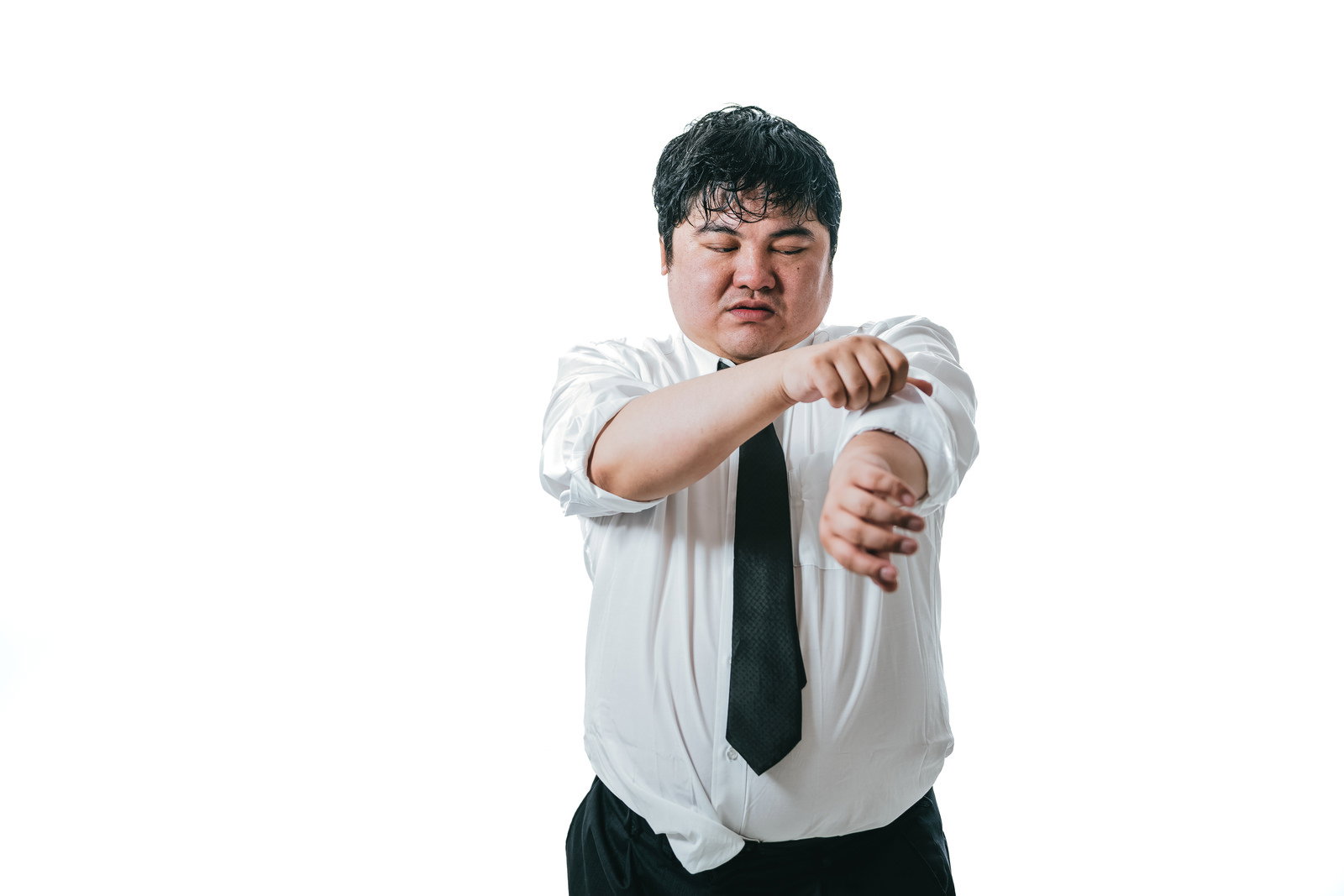 白いシャツの袖をまくり上げる黒いネクタイの男性会社員［モデル：段田隼人］