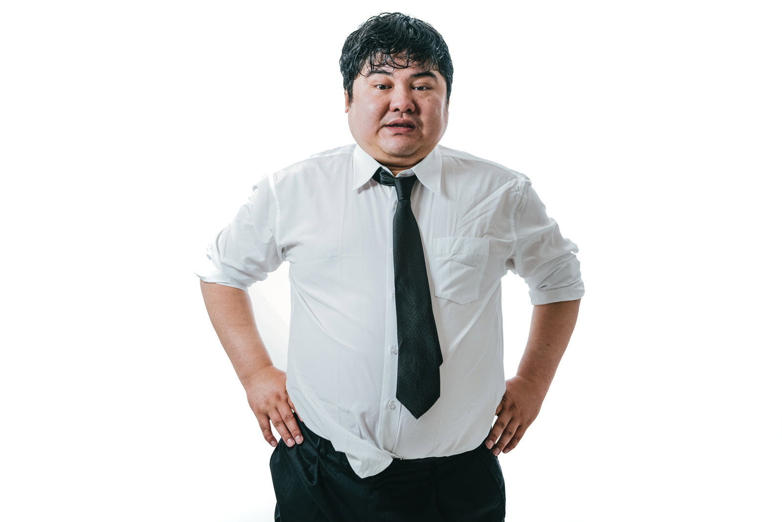 白いワイシャツにグレーのネクタイを着用し、両手を腰に当てて立つ中年男性［モデル：段田隼人］